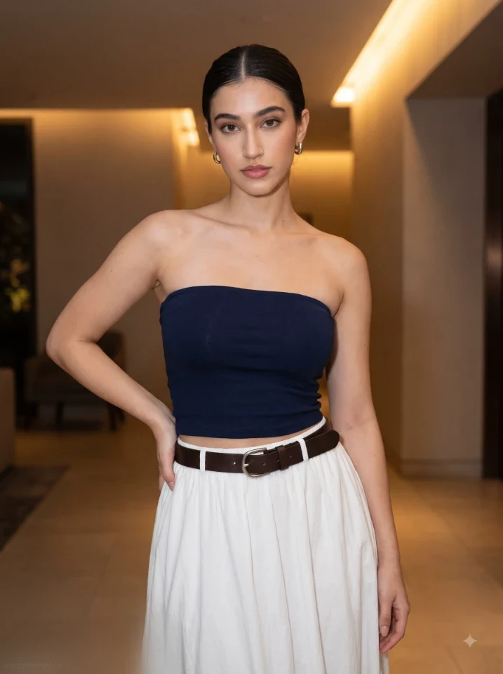 ChatGPT girl prompt output featuring a navy tube top white maxi skirt and brown belt in a warm ambient interior light setting with editorial composition
