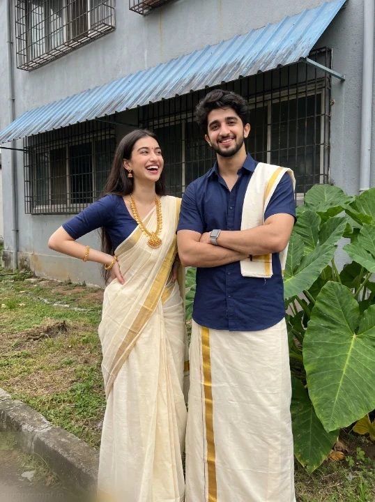 Onam 2026 Gemini prompt couple standing navy blouse kasavu saree cream mundu angavastram front yard tropical green